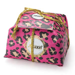 A panettone cake with black cherry and chocolate chips, wrapped in a pink and brown animal patterned paper, and a label that reads 'GOOD PANETTONE AWARD OF LOMBARDY'.