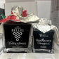 Two bottles of aceto balsamico with decorative packaging on a table.
