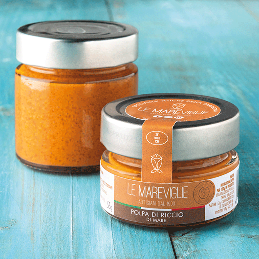 two jars of sea urchin pulp on a blue table