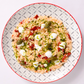 Plated dish of risotto with semi-dried tomatoes, capers and capers fruits on a white background