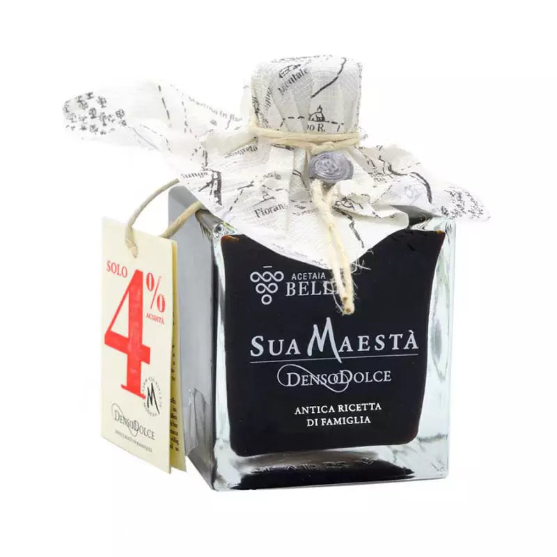 Small bottle of Su Maestà with decorative packaging on a white background
