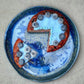 Decorative plate with a pie and blueberries on a textured surface_deep blue foodcolor