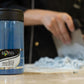 Blue container labeled 'Roma' on a table with a blurred background_ blue deep foodcolor