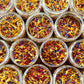 Jars filled with colorful dried flowers arranged in a grid pattern.