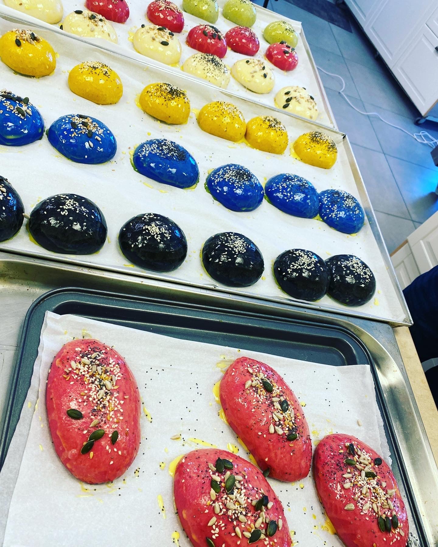 Colorful pastries on trays with a kitchen background