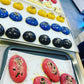 Colorful pastries on trays with a kitchen background