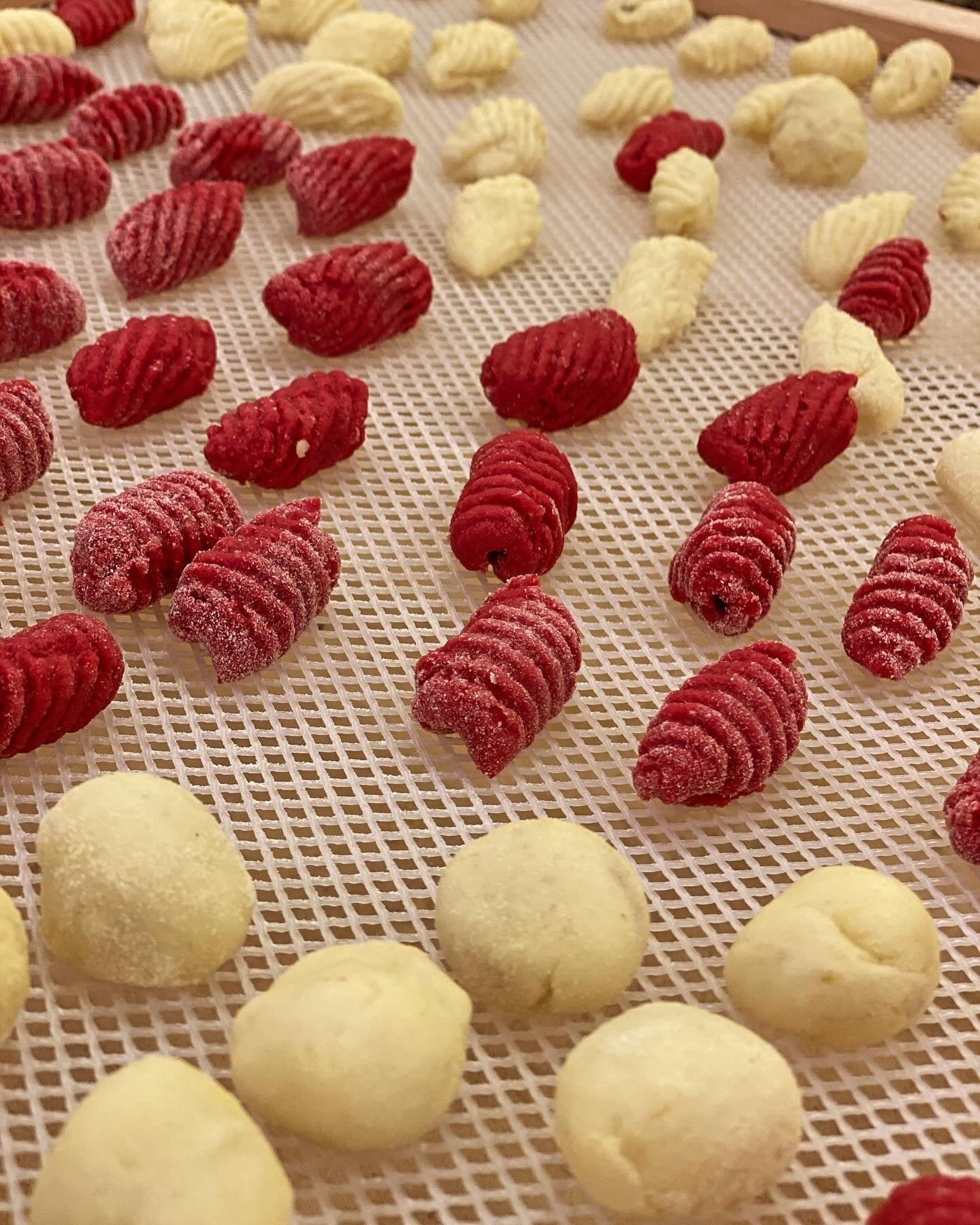 Red and white gnocchi on a mesh tray