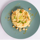 Risotto dish on a green plate with a risotto with hazelnuts, herbs and sage and lemon sauce 