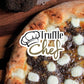 pizza on a wood table with truffle sauce of truffle chef brand, and fresh black truffle