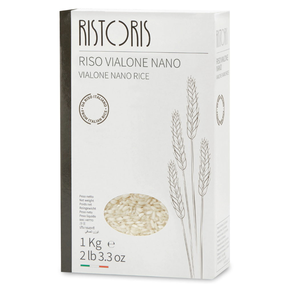 A 1 kg box of Ristoris Vialone Nano Rice, featuring a white packaging design with a dark gray spine, minimalist wheat illustrations, and a circular window showing the rice grains inside.