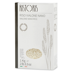 A 1 kg box of Ristoris Vialone Nano Rice, featuring a white packaging design with a dark gray spine, minimalist wheat illustrations, and a circular window showing the rice grains inside.