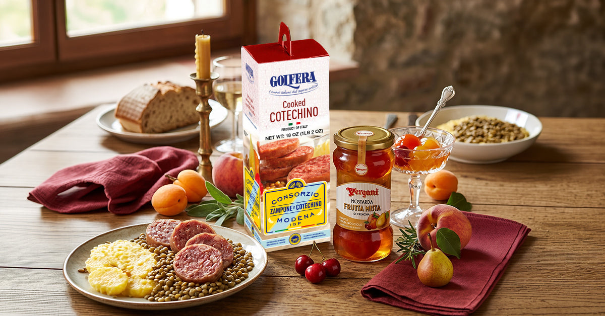Table setting with food items and a box of Golafera Cotechino on a wooden table.